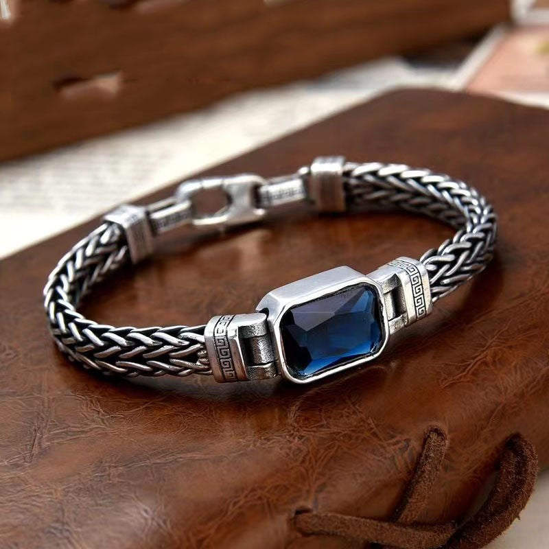.A silver bracelet featuring a striking blue stone, elegantly designed to enhance any jewelry collection.