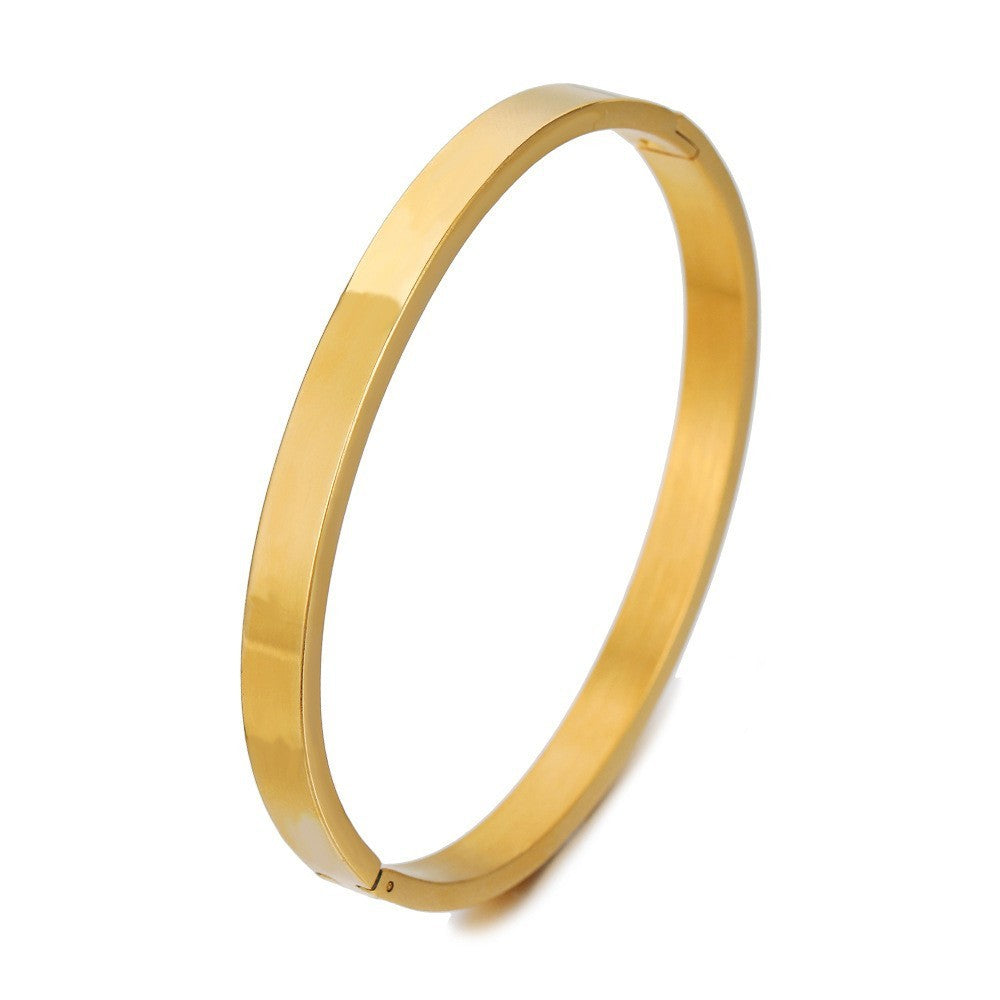 A simple gold bang bracelet displayed on a clean white background, highlighting its elegant design and shine.