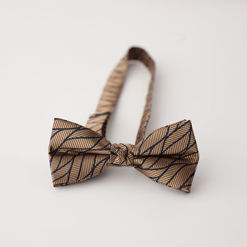 A stylish bow tie and a small wooden bowl are placed on a table, highlighting a unique combination of sophistication and simplicity.
