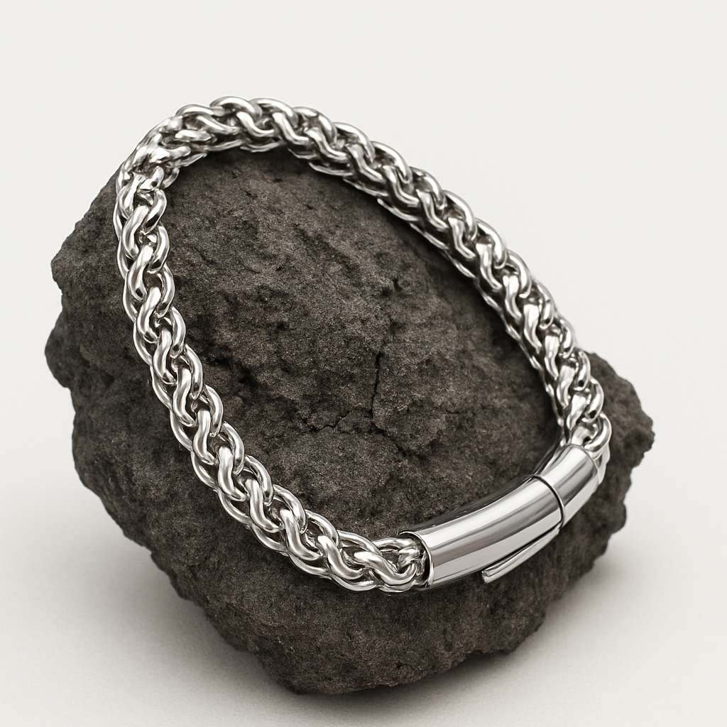 Silver chain bracelet on a dark stone surface with a white background