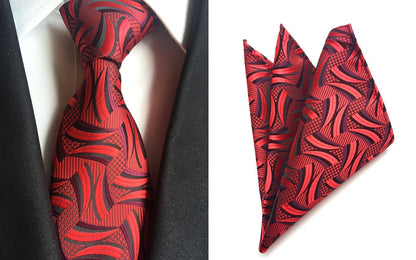 A red tie paired with a black suit featuring a subtle red pattern, showcasing a sophisticated and stylish ensemble.