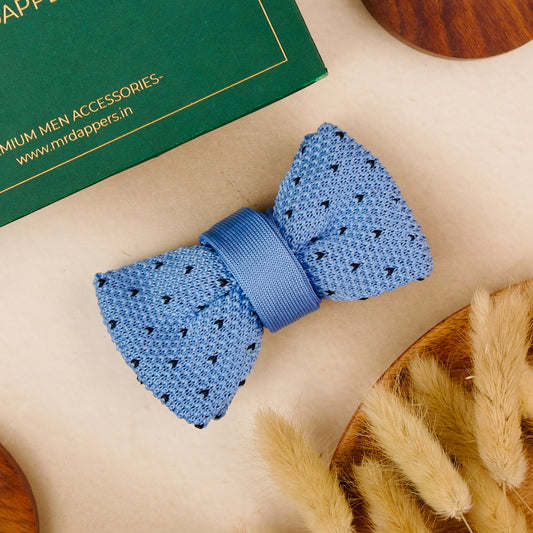 A blue bow tie elegantly placed on a polished wooden table, showcasing its vibrant color and texture.