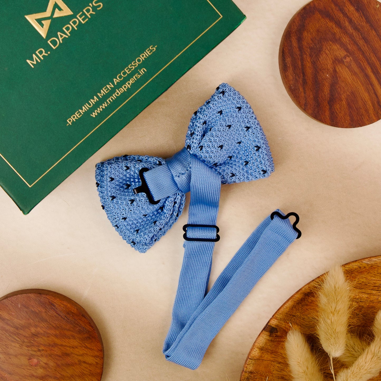 A blue bow tie elegantly placed on a polished wooden table, showcasing its vibrant color and texture.