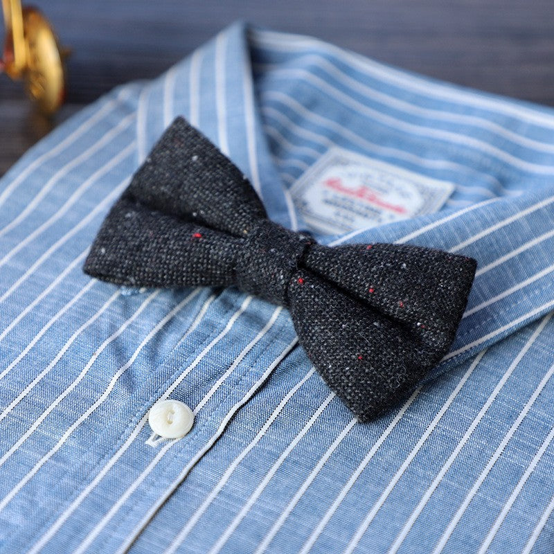  A black bow tie elegantly placed beside a polished wooden box, showcasing a classic and sophisticated arrangement.
