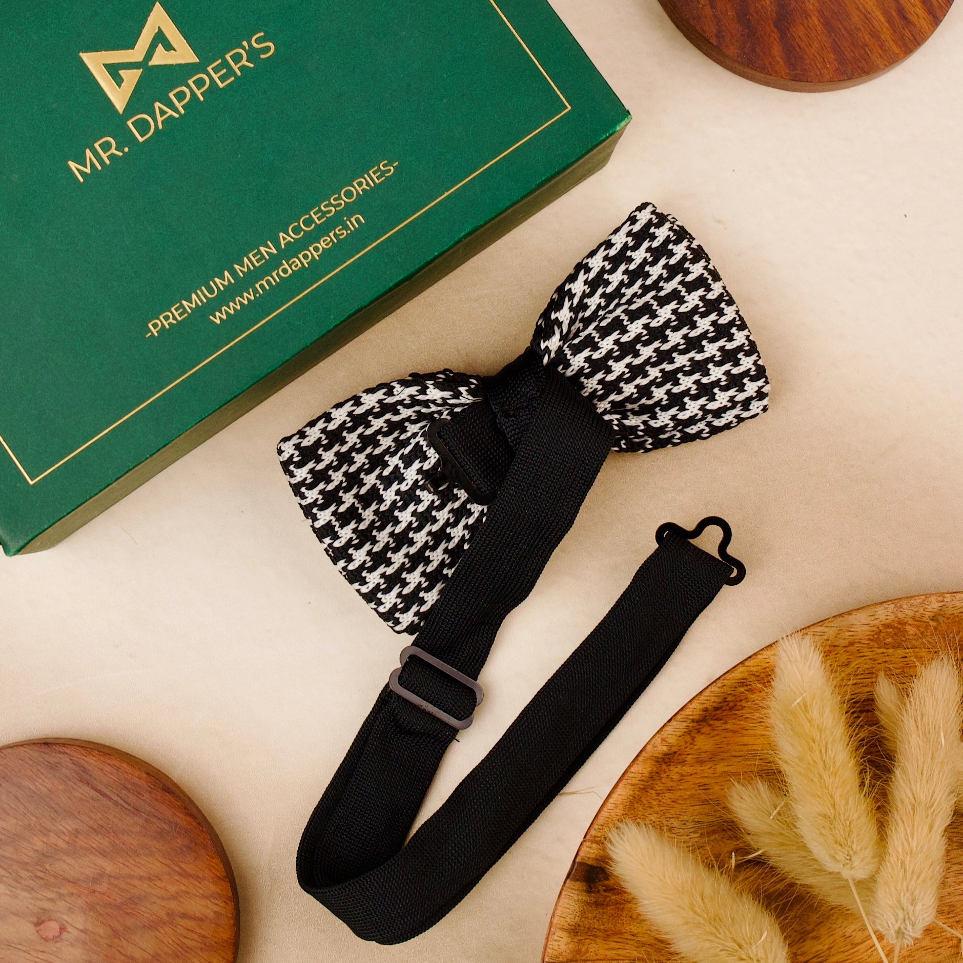  A black and white bow tie elegantly placed on a rustic wooden table, showcasing its classic design and texture.