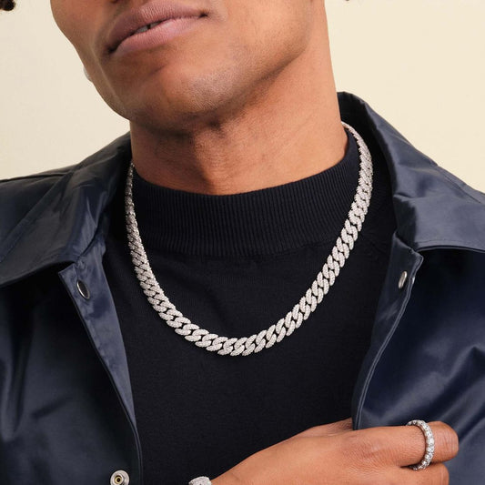 Person wearing a silver chain necklace and bracelet on a neutral background